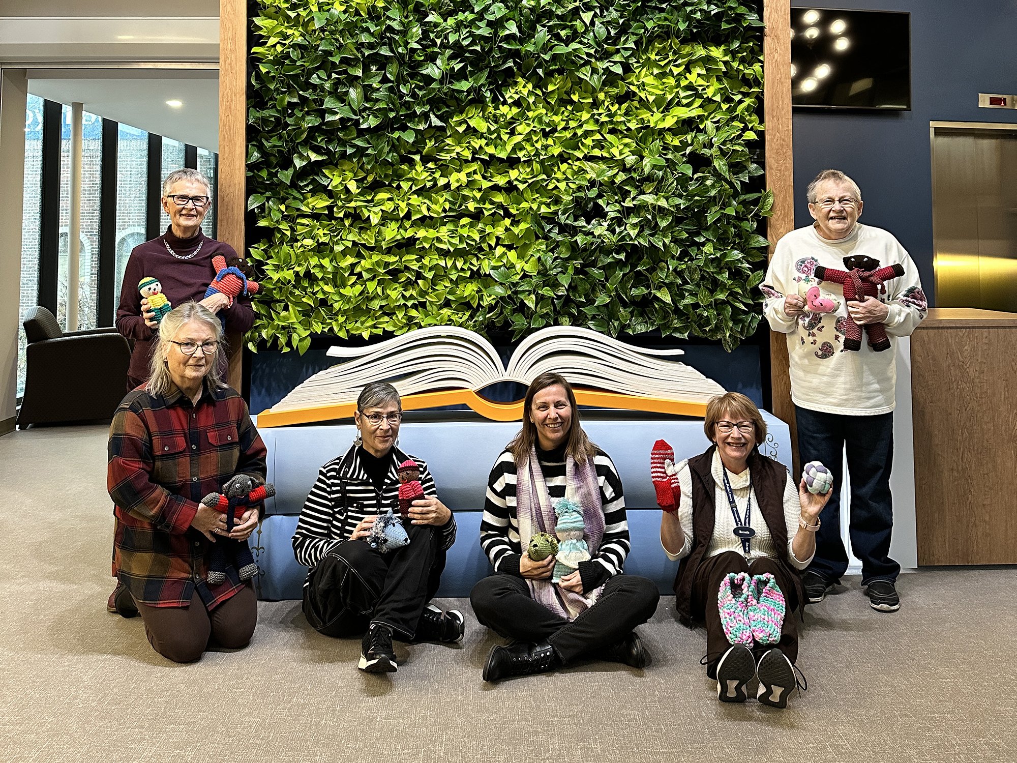 A group of people sit in front of the living wall at the Orangeville Public Library